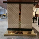 High-Gloss Amber Burl Wood Dining Table with Cream Quilted Leather Base and Metal Inlay